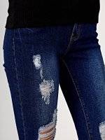 Damaged skinny jeans in dark blue wash