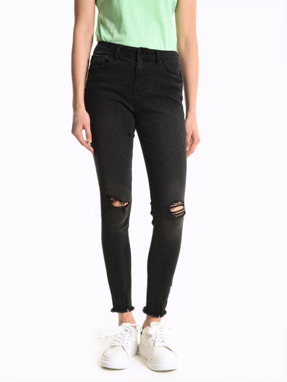 Skinny jeans with damages and raw hems