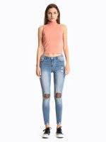 Distressed skinny jeans with fishnet