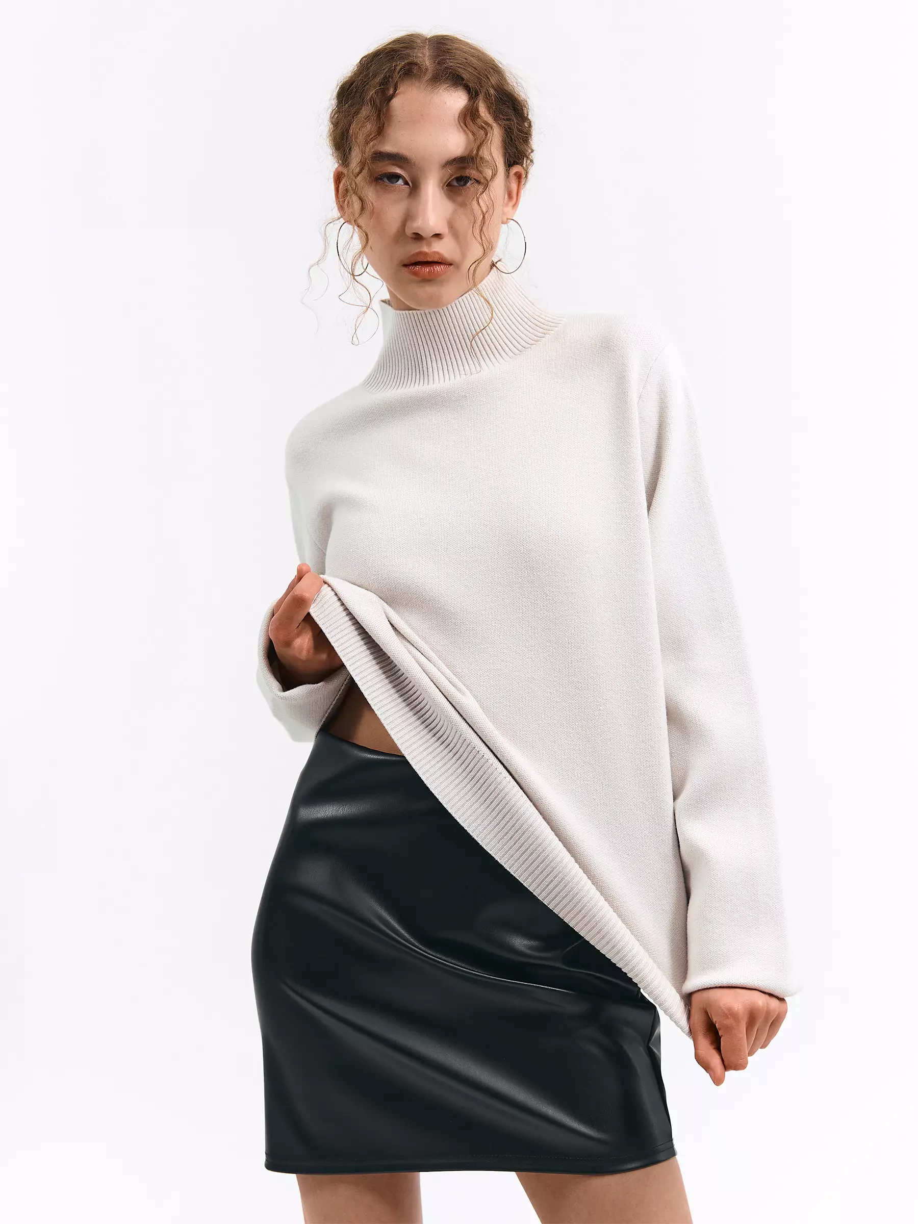 Woman in a faux leather skirt with a cozy knit sweater